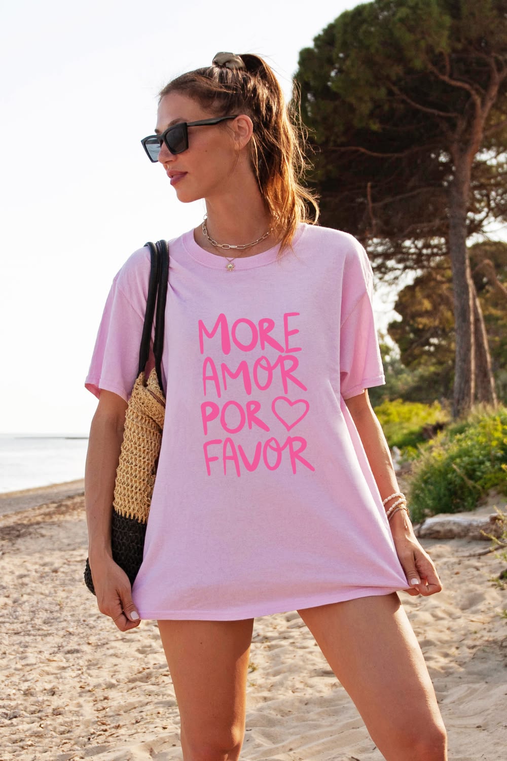 Frau am Strand in rosa Oversize-T-Shirt mit dem pinken Schriftzug More Amor Por Favor